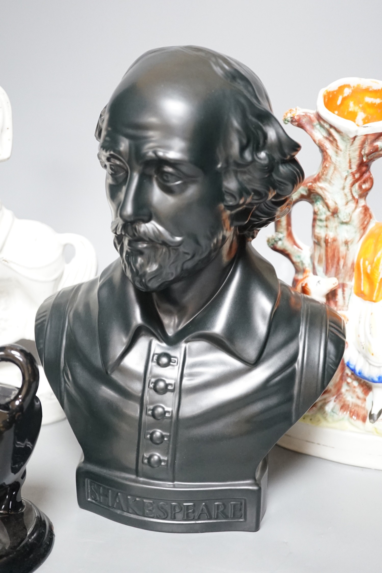 A Wedgwood glazed black basalt bust of Shakespeare, two Victorian Staffordshire figures and a cow creamer, tallest 27cm